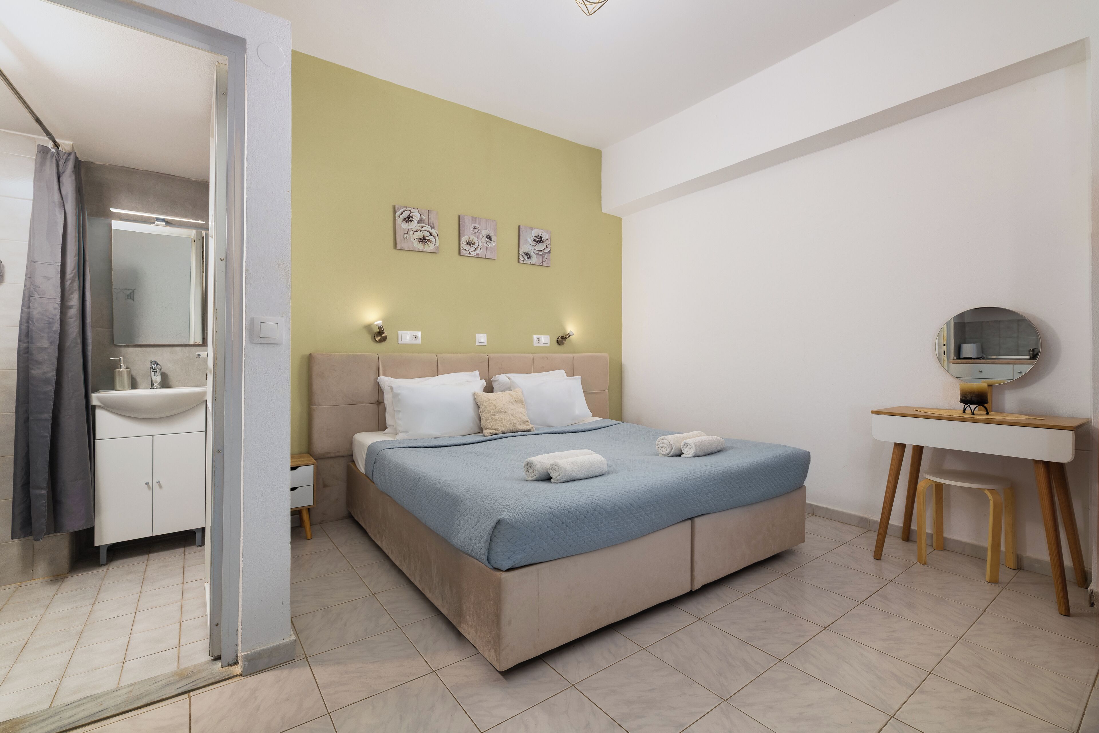 A bedroom with a bed, bedside table, and a mirror.