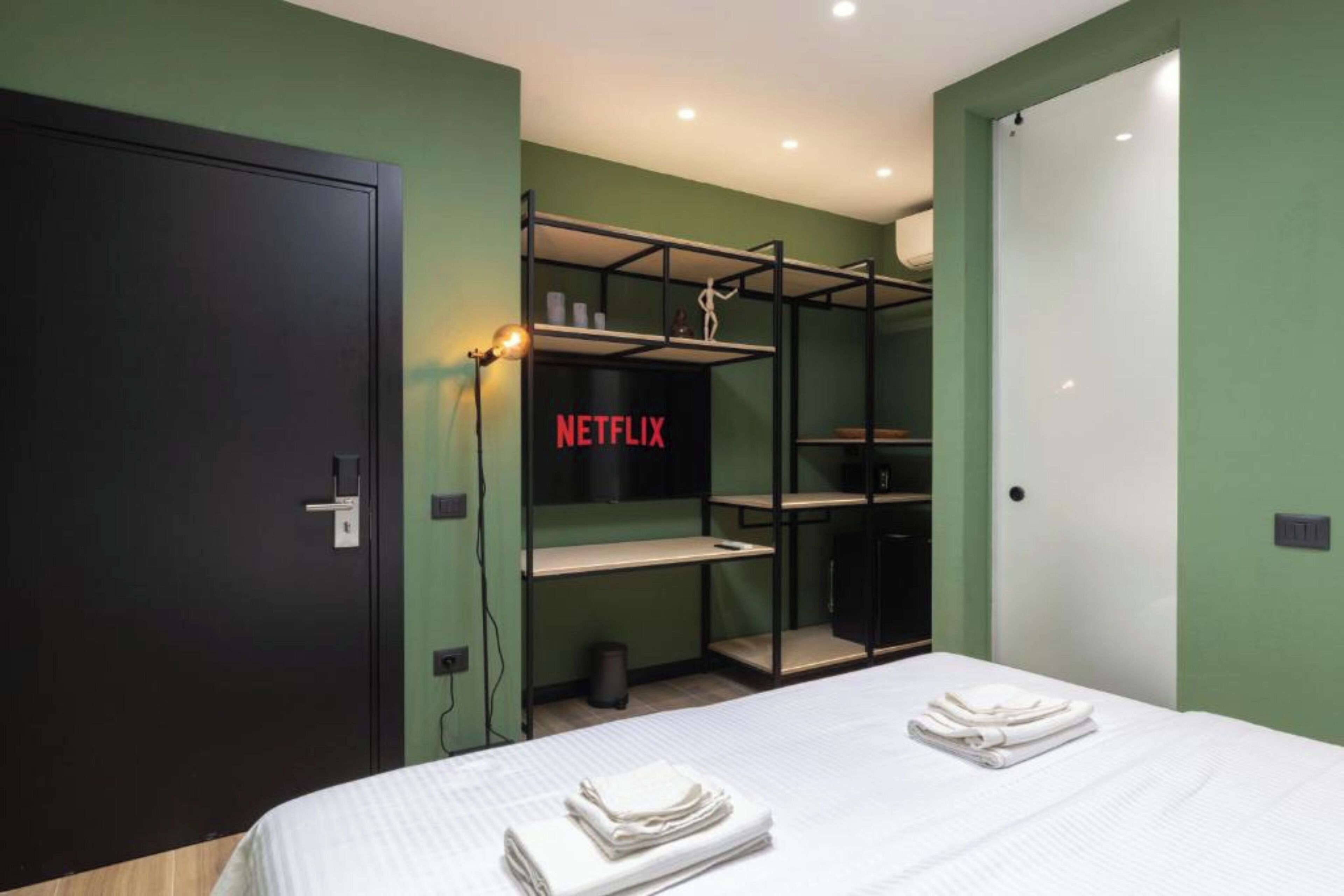 Una habitación moderna con una cama, un armario y una estantería con el logo de Netflix.