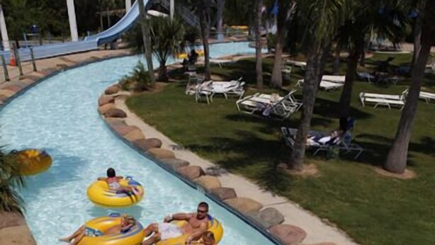 A water slide with people on inflatable tubes. - Premier Retreat: Pool & Steps from Waterville (Gulf Shores)