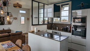 Una cucina moderna con un'isola centrale, elettrodomestici in acciaio inossidabile e un'ampia finestra che offre luce naturale.