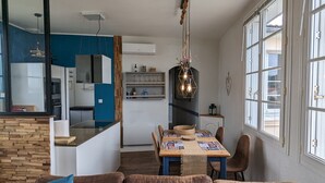Una cucina moderna con armadietti blu, un'isola in legno e un'area pranzo con tavolo apparecchiato per due.