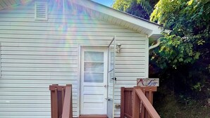 A house with a wooden deck, a white door, and a small porch. - Miraflor Guest House, family and pet friendly (Sylva)