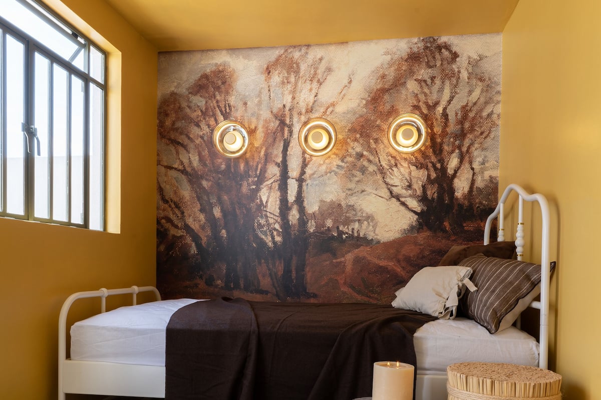 Une chambre à coucher avec un lit, une table de chevet, une lampe et un tableau au mur.