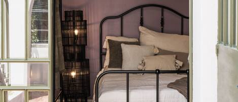 A bedroom with a bed, a nightstand, and a lamp.