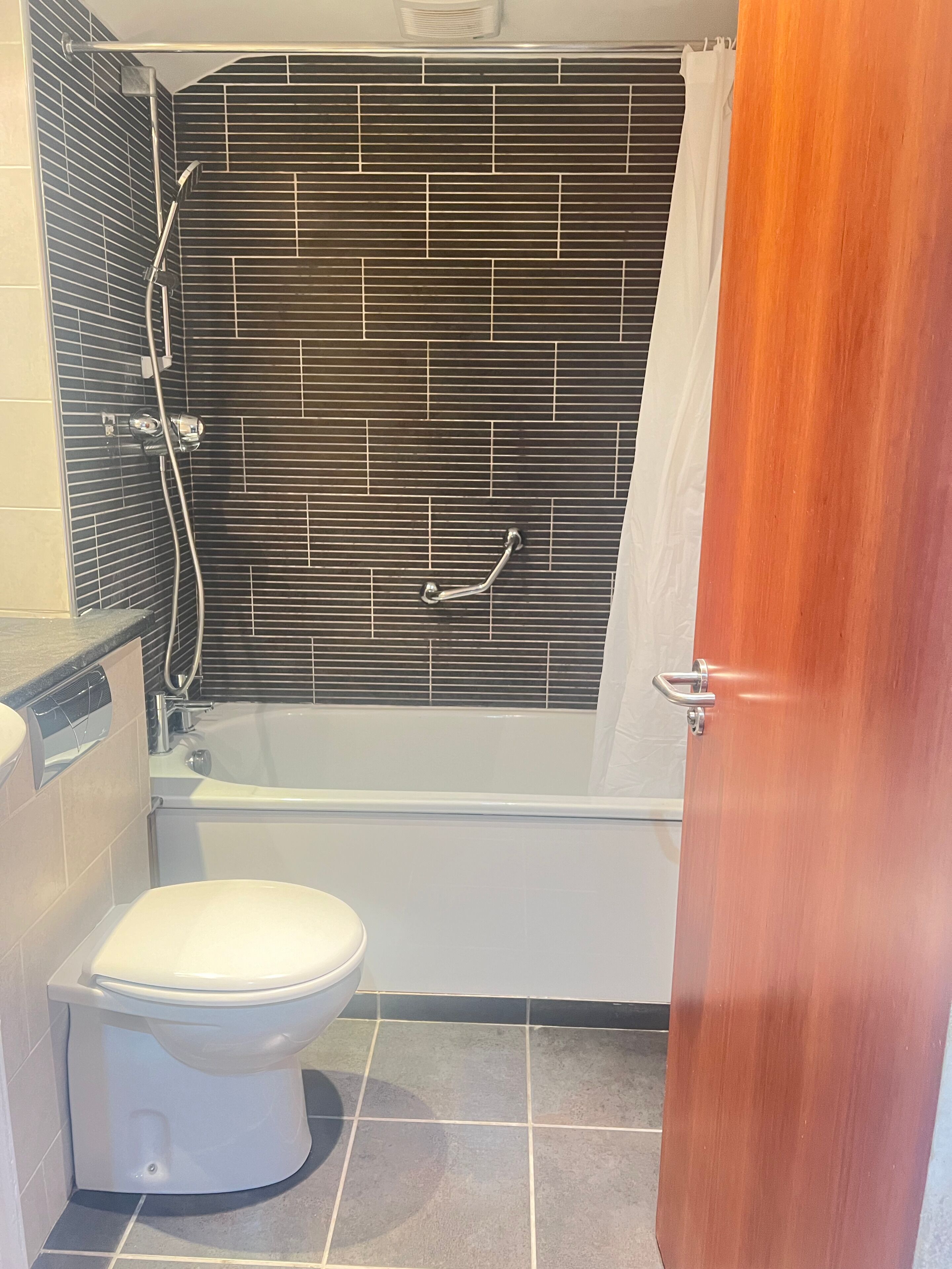 Ein Badezimmer mit Badewanne, Toilette und Duschbereich.