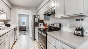 A modern kitchen with white cabinets, stainless steel appliances, and a built-in oven.