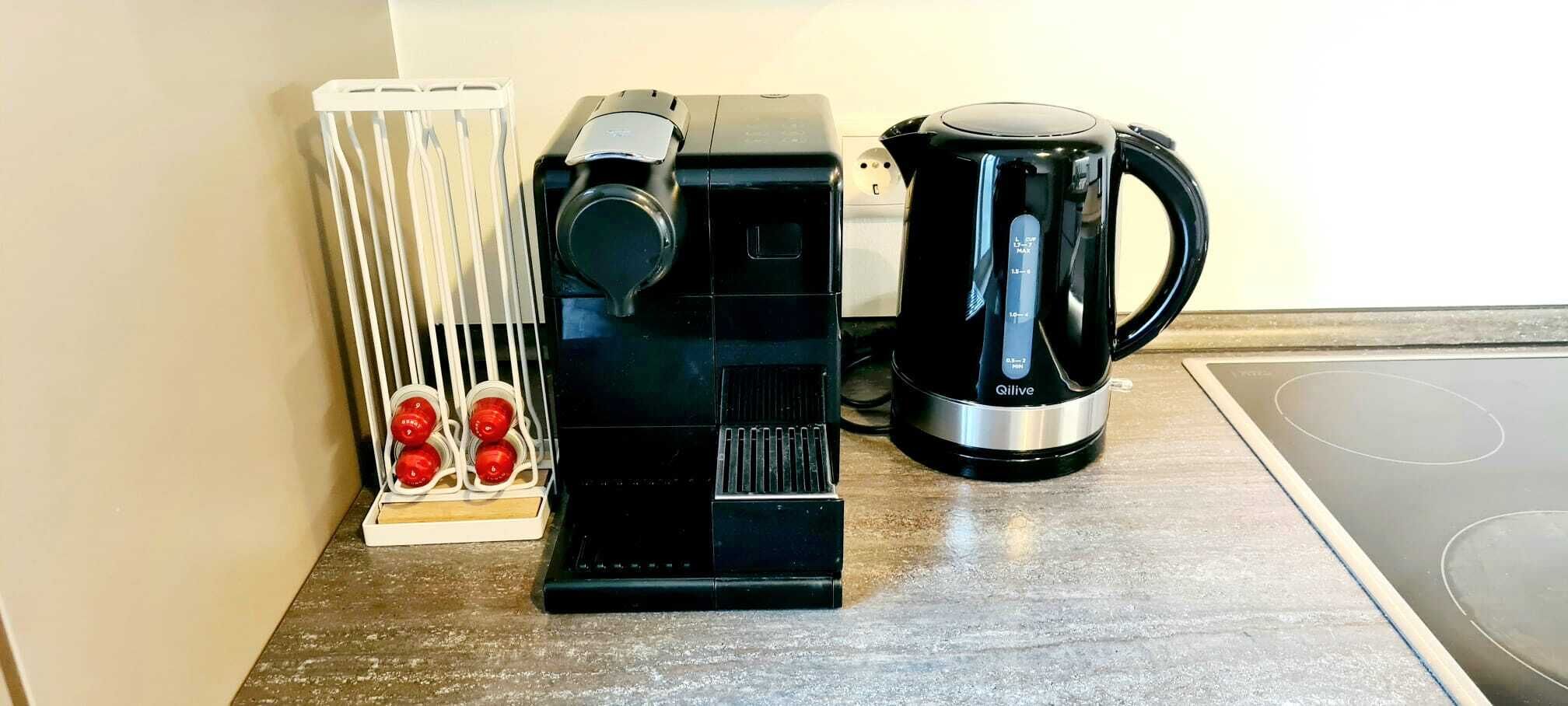 Una cafetera, un hervidor y un radiador sobre una encimera de cocina.