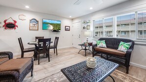 A spacious living area with a dining table, chairs, a sofa, and a coffee table.