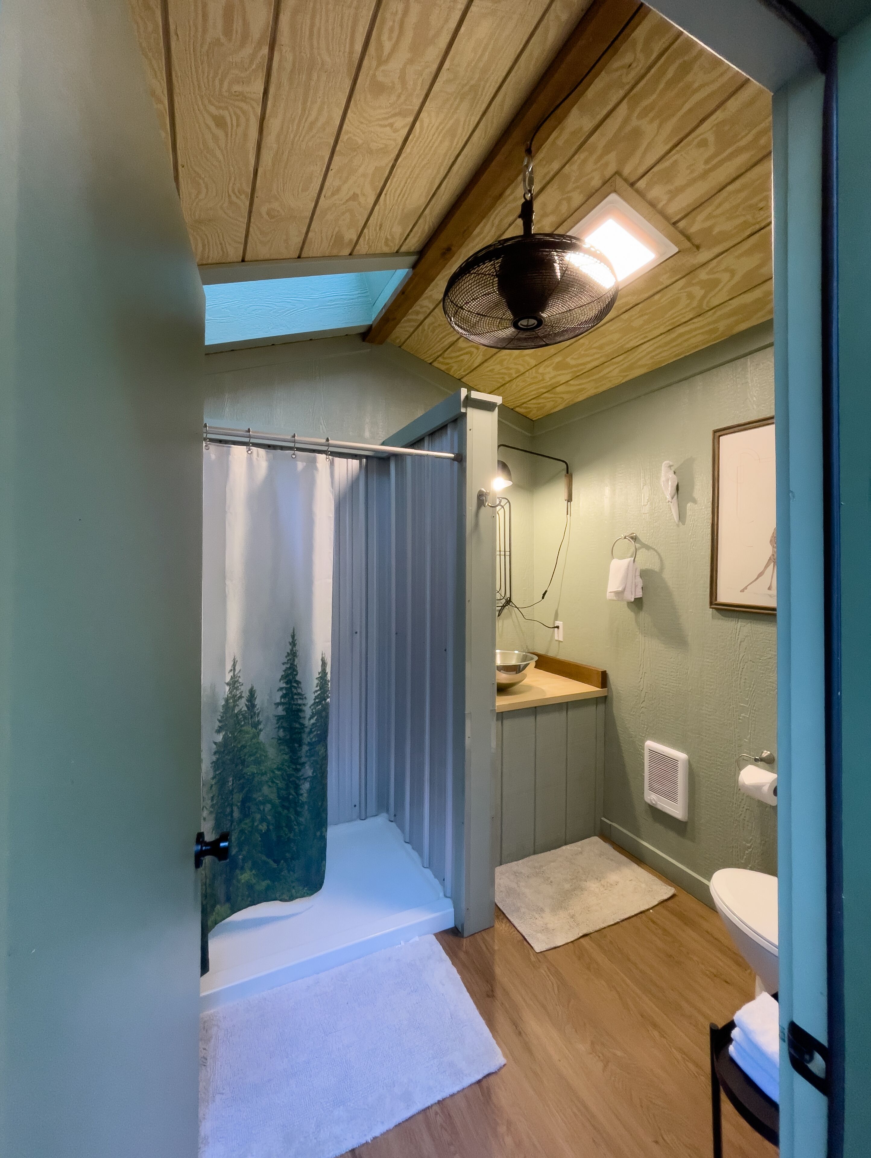 Ein Badezimmer mit Dusche, Toilette, Waschbecken und Handtuchhalter.