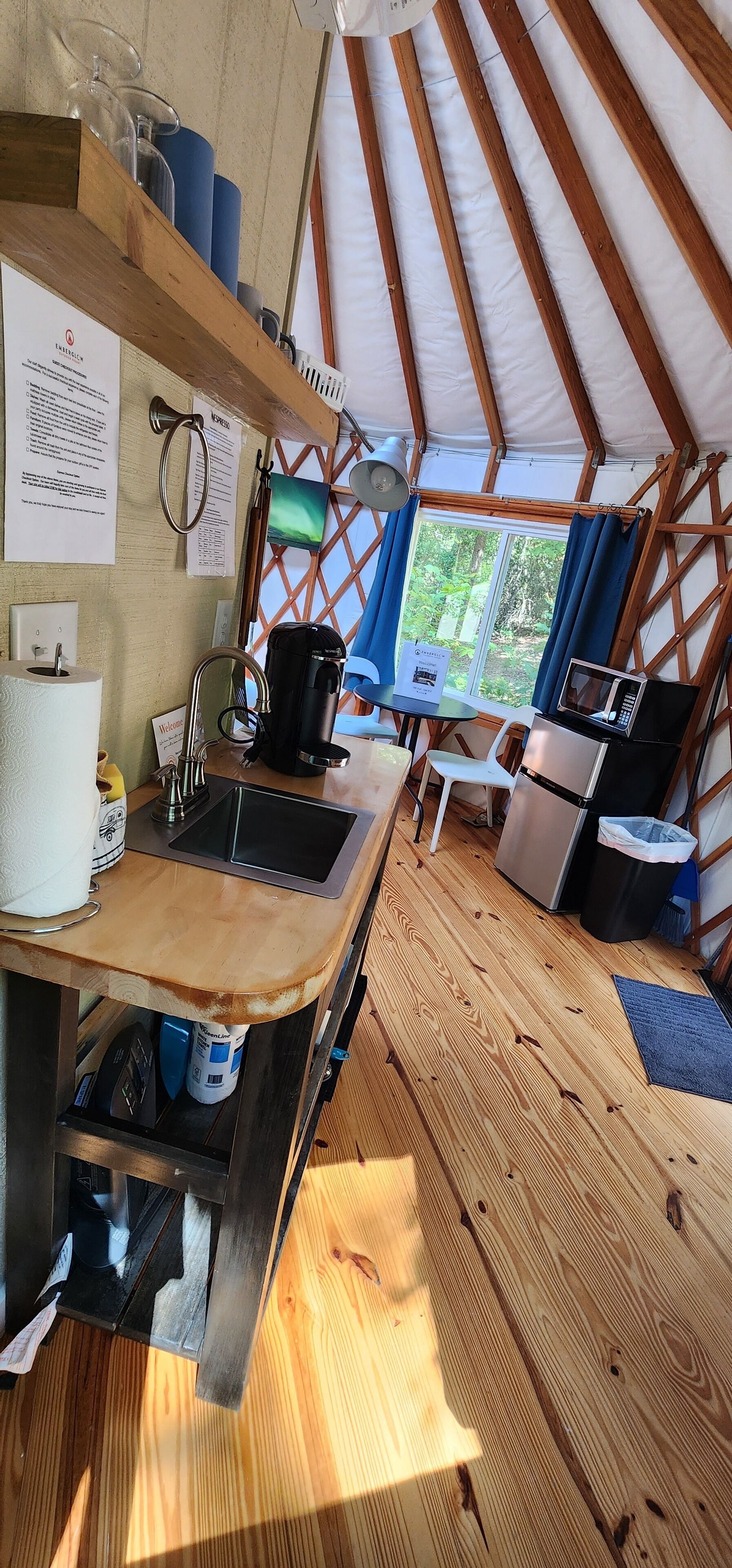 A compact kitchen with a sink, coffee maker, and microwave.