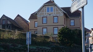A large, two-story building with a traditional architectural style, featuring a prominent gabled roof and multiple windows.