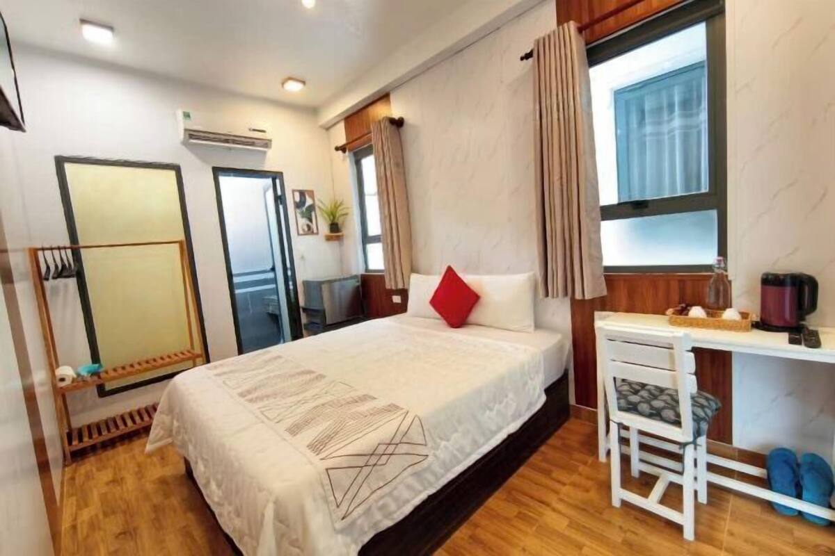Ein Hotelzimmer mit Bett, Schreibtisch, Stuhl und Fenster.