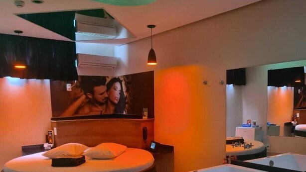 A modern bathroom with a circular bed, a large bathtub, and a mirror. - PRIME MOTEL AMERICANA (Americana)