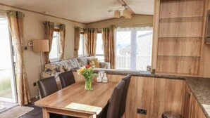 A dining area with a wooden table, chairs, and a vase of flowers.