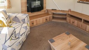 A living room with a flat-screen TV mounted on the wall, a sofa, and a coffee table.
