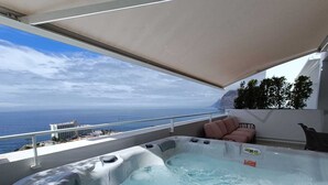 A hot tub on a balcony with a view of the ocean and a building in the background. - Maravilloso Triplex con Pisicna Privada, Jacuzzi y Sauna en los Gigantes (Santiago del Teide)