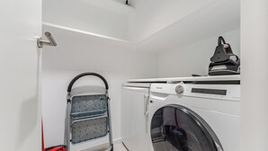 A laundry room with a washing machine, a drying machine, and a mopping bucket. - Maravilloso Triplex con Pisicna Privada, Jacuzzi y Sauna en los Gigantes (Santiago del Teide)