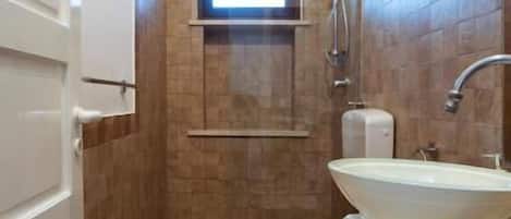 A small bathroom with a toilet, sink, and shower.
