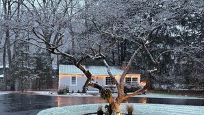 A snow-covered landscape with a house in the background.