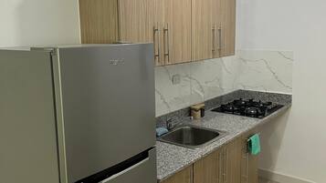 Refrigerador, cafetera/tetera, utensilios de cocina, mesa de comedor