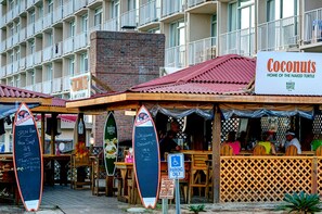 A beachfront restaurant named 'Coconuts' with outdoor seating and a sign indicating 'Home of the Naked Turtle'. - Two Bedroom, Ocean Front, Luxury Condo, North Myrtle Beach, SC 3935803 (North Myrtle Beach)