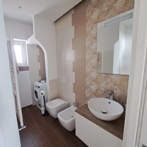 Een douche, een haardroger, een bidet, handdoeken