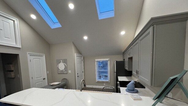 A modern kitchen with a large island, skylights, and built-in appliances. - Fantastic Location (Ogunquit)