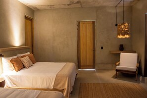 Un dormitorio con una cama grande, una silla, una puerta de madera y una lámpara colgante.