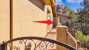 Un bâtiment à la façade beige, doté d’un portail en métal et d’un escalier menant à une porte.