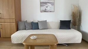 A modern living room with a beige sofa, a wooden coffee table, and a decorative wall piece. - Apartment in Schloß Nähe (Sögel)
