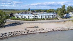 Un hotel costero con una hilera de edificios blancos, una playa de arena y un litoral rocoso.
