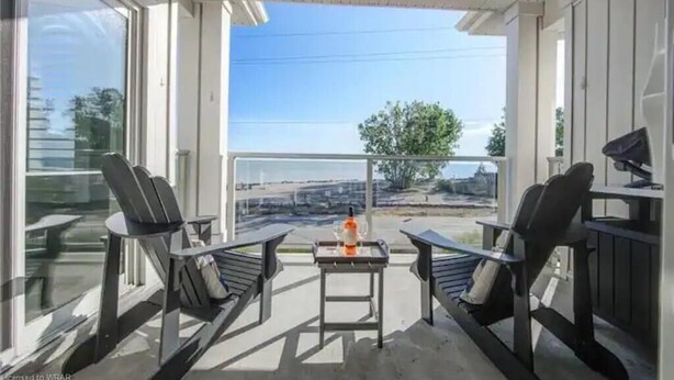 Un espacio al aire libre techado con dos sillas y una mesa, con vistas panorámicas.