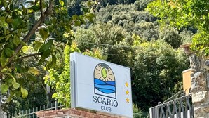 A sign for 'SCARIO CLUB' with a logo, set against a backdrop of a stone wall and greenery. - Scario Club (San Giovanni a Piro)