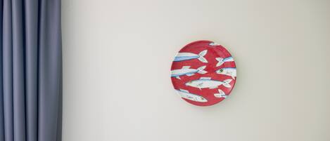 A wall with a red plate featuring fish patterns.