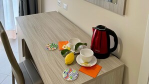 A modern room with a wooden table, a TV, a mirror, and a kettle. - Scario Club (San Giovanni a Piro)