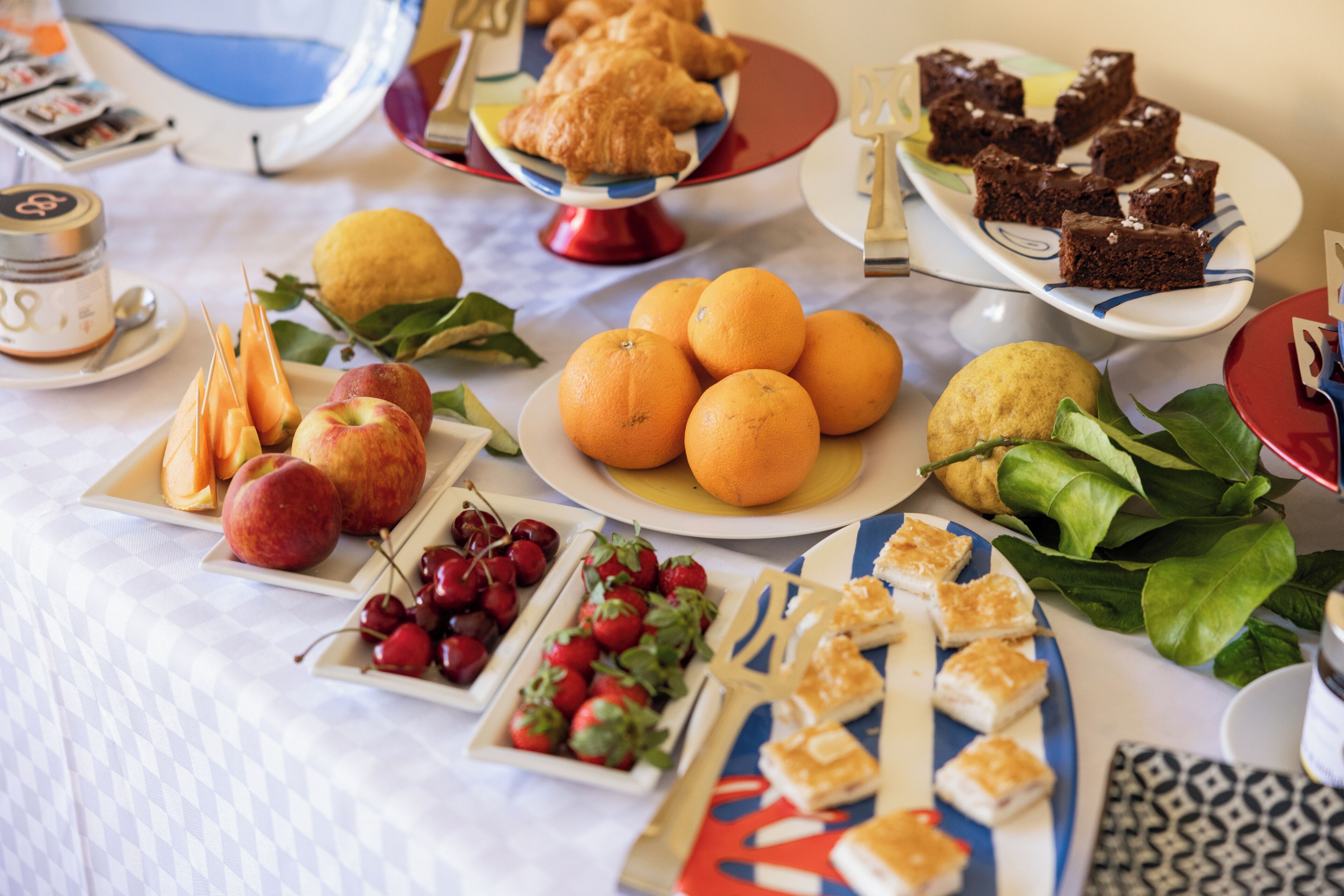 A table with various food items including fruits, pastries, and desserts.