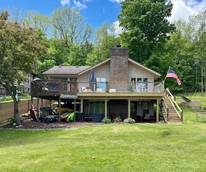 Une maison à deux étages avec une terrasse, un porche couvert et un drapeau américain.
