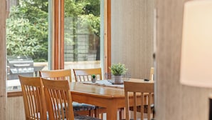 A wooden dining table with chairs, a small potted plant, and a lamp. - Harmony Ridge by AvantStay | Fireplace, Large Deck & Forest Views (Lake Harmony)