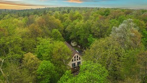 Una casa rodeada de un bosque frondoso con una vista despejada del cielo.