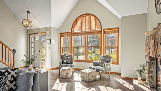 A spacious living room with a high ceiling, large windows, and a fireplace. - Laker's Pointe by AvantStay | Lakefront Private Peninsula | Hot Tub, Game Room (Long Pond)