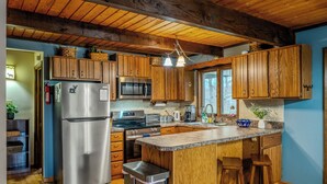 Une cuisine dotée de meubles en bois, d’appareils électroménagers en acier inoxydable et d’un plan de travail en granit.