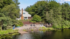 A lakeside cabin with a deck, outdoor seating, and a dock. - Simply Shores by AvantStay | Private Beach + Dock | Lake Overlook (Long Pond)