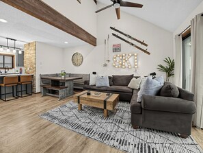 Un salon moderne avec un canapé, une table basse et une horloge au mur.