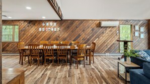 Un comedor con piso de madera en espiga, una mesa de comedor de madera con sillas, y un sofá azul con una mesita auxiliar.