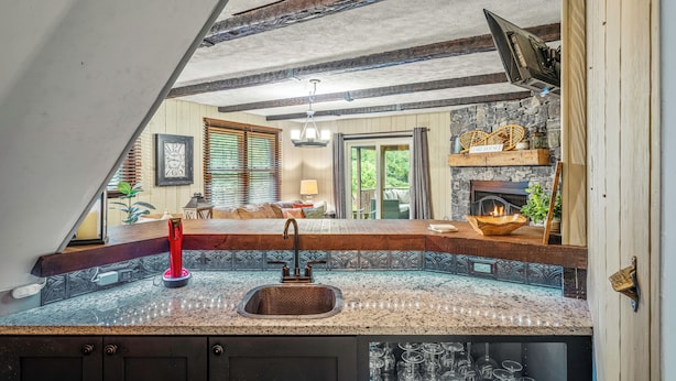 Een keuken met een granieten aanrecht, een spoelbak en een ingebouwde wijnrek.