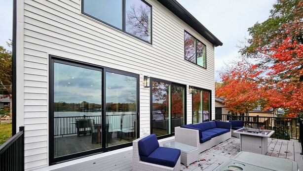 A deck with outdoor furniture and a grill. - Newly Built Lakefront w/ Deck & Views | Lakeside Serenity by AvantStay (White Haven)