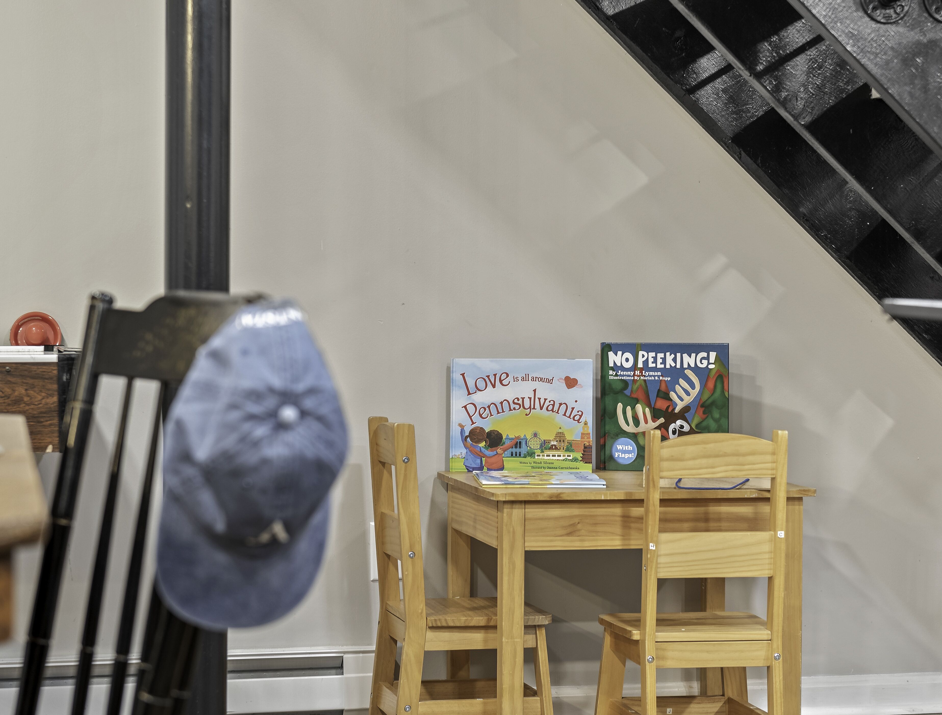 Une table en bois sur laquelle reposent deux livres intitulés « L’amour est partout en Pennsylvanie » et « Ne trichez pas ! », ainsi qu’un chapeau.