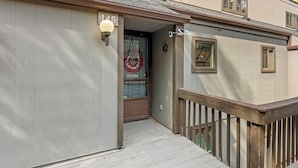 A building with a wooden deck, a number '146' sign, and a wreath on the door.