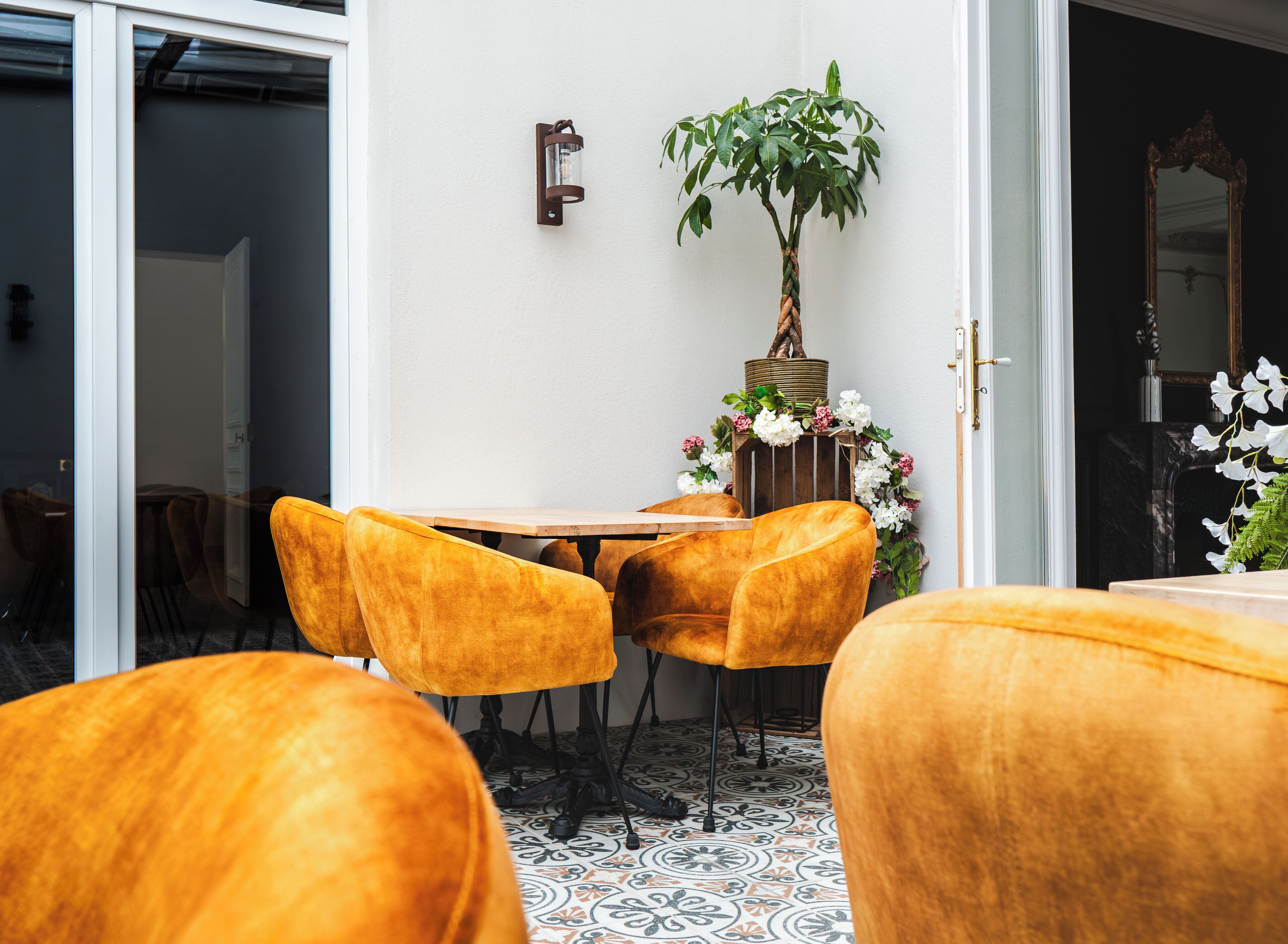 A dining area with a table and chairs, a potted plant, and a decorative wall-mounted light fixture.
