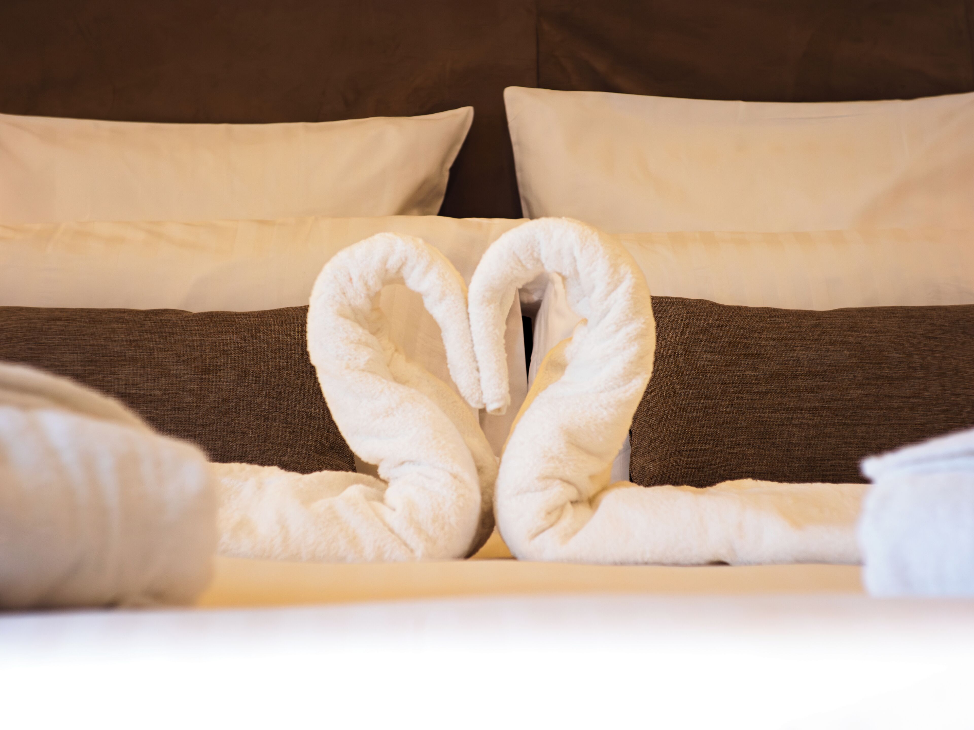 Een bed met een handdoekopstelling in de vorm van een hart.